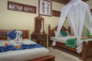 a bedroom with two beds and a canopy bed at Suparsa's Homestay in Ubud