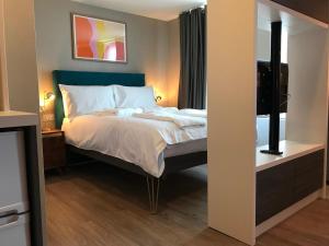 a bedroom with a large bed and a mirror at Aaron Wise - 62 Plantagenet Studios in Cardiff