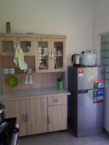 Una cocina con refrigerador de acero inoxidable y gabinetes de madera. en Maxim Apartment, en Pantai Cenang 32 fotos más