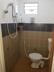 un baño con inodoro y ducha en Maxim Apartment, en Pantai Cenang