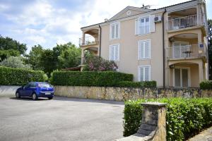 ein blaues Auto, das vor einem Gebäude parkt in der Unterkunft Apartment Diana in Vantačići