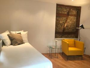 ein Schlafzimmer mit einem Bett und einem gelben Stuhl in der Unterkunft Büdinger Hof in Weinheim