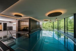 einen Innenpool mit blauem Wasser in einem Haus in der Unterkunft Schmalzlhof Hotel & Apartments in Oberrasen