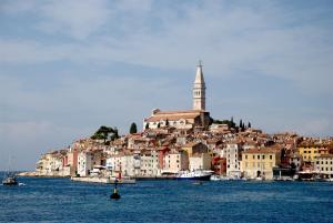 a city on the shore of the water with a church at Charmy Rovinj in Rovinj