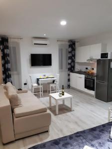 ein Wohnzimmer mit einem Sofa und einer Küche in der Unterkunft Charmy Rovinj in Rovinj
