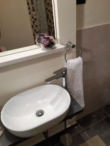La salle de bains est pourvue d'un lavabo blanc et d'un miroir. dans l'établissement Charmy Rovinj, à Rovinj