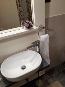 a bathroom with a white sink and a mirror at Charmy Rovinj in Rovinj