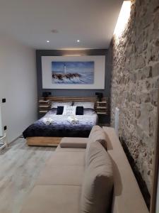 ein Schlafzimmer mit einem Bett und einer Steinmauer in der Unterkunft Charmy Rovinj in Rovinj