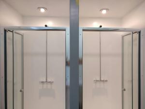 a row of glass doors in a room with lights at Birmingham Central Backpackers in Birmingham