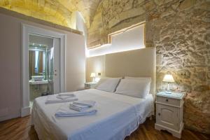 - une chambre avec un lit et des serviettes dans l'établissement Chiesa Greca - SIT Rooms & Apartments, à Lecce