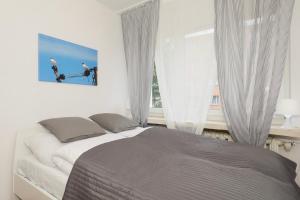 コウォブジェクにあるJantar Home - Mieszkanie w centrum z 2 sypialniamiのベッドルーム1室(ベッド1台付)、窓(白いカーテン付)