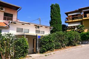 a white house with bushes in front of a street at Trsatika in Rijeka