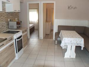 eine Küche mit einem Tisch und einem Sofa sowie ein Zimmer in der Unterkunft Nika nyaraló jakuzzival in Balatonkeresztúr