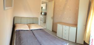 ein kleines Schlafzimmer mit einem Bett und einer Küche in der Unterkunft Nika nyaraló jakuzzival in Balatonkeresztúr