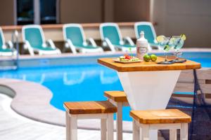 a table with drinks and snacks next to a swimming pool at Aparthotel Los Dragos del Sur in Puerto de Santiago