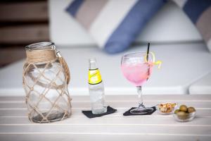 a table with a drink and a bottle and a glass at Aparthotel Los Dragos del Sur in Puerto de Santiago