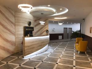 a lobby with a reception counter and a yellow chair at Ideal city in Tutin