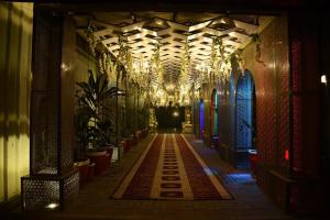 a hallway with chandeliers and plants in a building at Marian Hotel in Ahmad Shāh