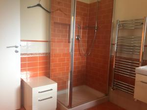 La salle de bains est pourvue d'une douche et de carrelage rouge. dans l'établissement Mansarda a pochi passi dal mare, à Brolo