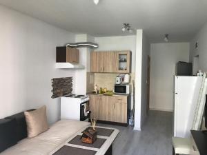a living room with a couch and a kitchen at Apartamenti Ely in Pomorie