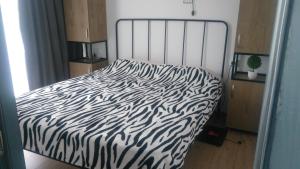 a bed with a black and white zebra print sheets at Apart Hotel ART in Bakuriani