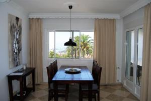 een eetkamer met een tafel en een raam bij Villa Sandra Top Floor Escape in Nerja