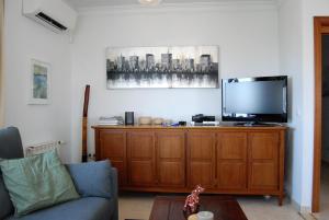 een woonkamer met een tv op een houten kast bij Villa Sandra Top Floor Escape in Nerja