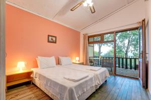 a bedroom with a large bed and a balcony at Assos Terrace Hotel in Behramkale