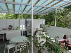 a woman sitting under a pergola on a patio at White Guest House in Batumi