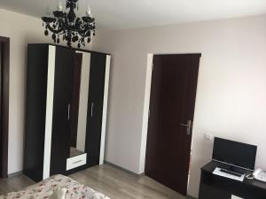 sypialnia z łóżkiem, lustrem i żyrandolem w obiekcie Pensiunea Crinul Alb w mieście Deseşti
