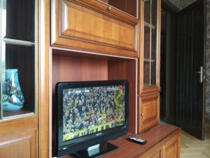 a television in a cabinet with a football game on it at New Apartment with 2 Isolated Bedrooms in Lviv