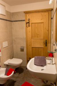 a bathroom with a white sink and a toilet at Apperlehof in Villabassa