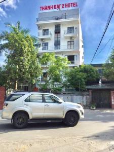 um carro branco estacionado em frente a um edifício em Thanh Dat 2 Hotel em Vinh