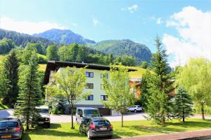 a view of a building with cars parked in front at Green Wall Apartment Kaprun in Kaprun