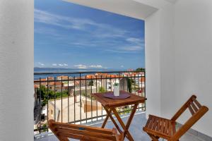 a balcony with a table and a view of the ocean at Apartmani Daniela Podgora in Podgora