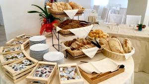 a table topped with baskets of bread and baskets of pastries at Hotel Punta Negra in Alghero
