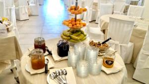 a table with a vase of fruit on top of it at Hotel Punta Negra in Alghero