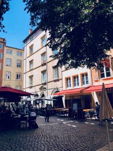 een straat met tafels en stoelen en een gebouw bij Honorê - Suite Trois Maries in Lyon