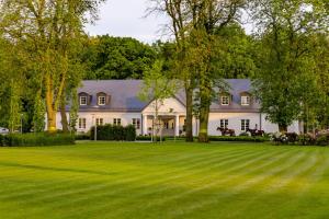 a large white house with a large lawn at Ostoja Chobienice in Chobienice