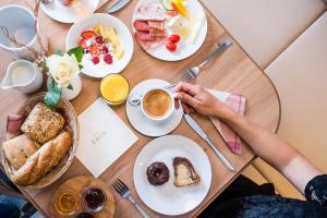 een persoon aan een tafel met een kopje koffie bij Hotel Zach in Innsbruck