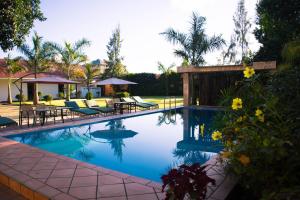 a swimming pool with tables and chairs in a yard at Tulia Boutique Hotel & Spa in Arusha +34 photos