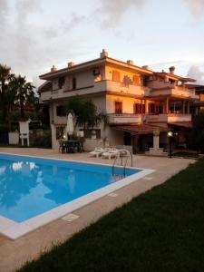 a large house with a swimming pool in front of it at Agriturismo Pinturicchio in Capo Vaticano