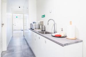 a kitchen with white cabinets and a sink at NOVUMHOUSE - Tomasza in Krakow