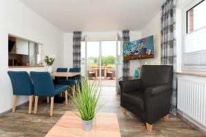 a living room with a table and a chair at Haus zur Möwe mit Frühstücksoption in Bensersiel