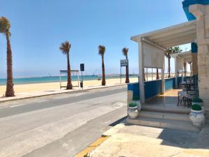 an empty street next to a beach with palm trees at Terrazze Sul Mare in Pozzallo