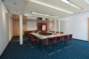 a conference room with a long table and red chairs at Hotel Penz West in Innsbruck
