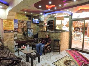 Un uomo seduto in un bar in un ristorante di Valentine Inn a Wadi Musa