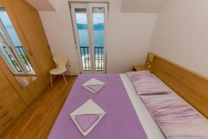 Cama en habitación con manta morada en Apartment Marija, en Trogir