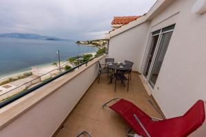balcón con mesa, sillas y vistas al océano en Apartment Marija, en Trogir