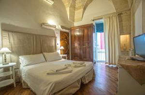 a bedroom with a bed with two towels on it at Chiesa Greca - SIT Rooms & Apartments in Lecce